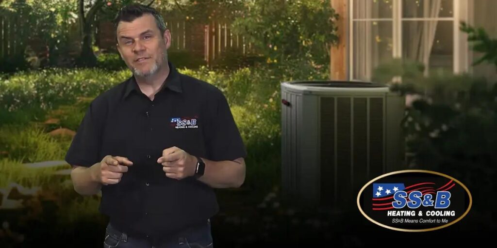 An SS&B Heating & Cooling technician standing outdoors near an energy-efficient heat pump, highlighting expert HVAC services and reliable solutions.