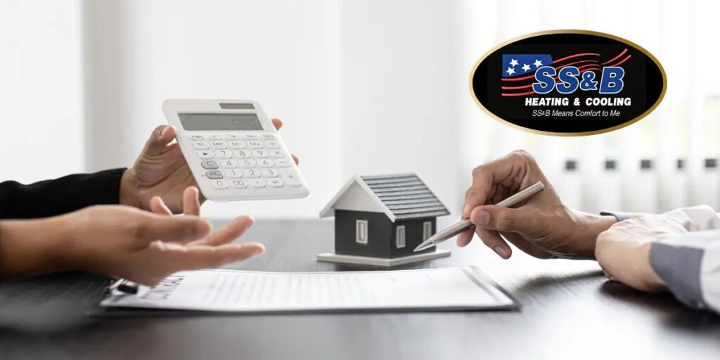 Two individuals discussing HVAC options with a model house, calculator, and documents on a table, featuring the SS&B Heating & Cooling logo.